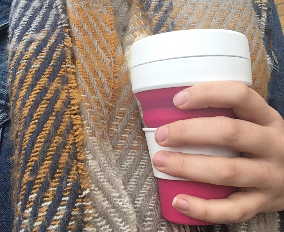 a thick scarf and a hand holding a hot drink