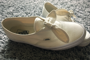 white canvas pair of vans with a bow
